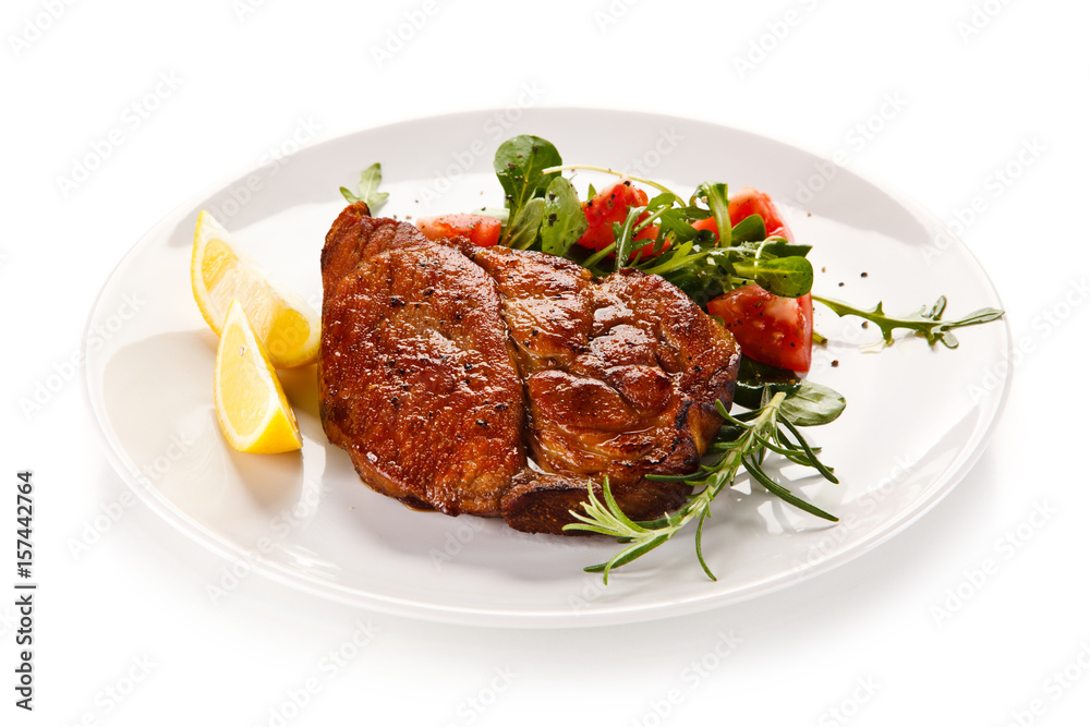 Grilled beefsteak with vegetables on white background Grilled beefsteak with vegetables on white background