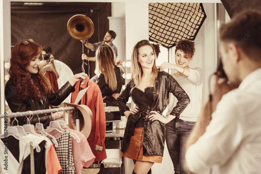 Stylist putting clothes on model