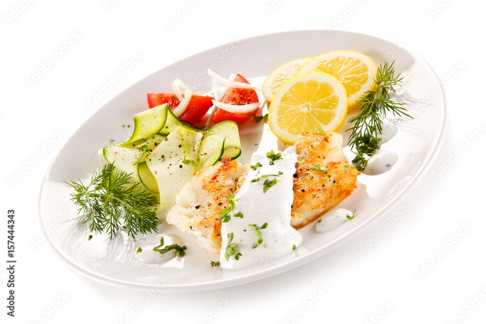 Fried cod and vegetables on white background Fried cod and vegetables on white background