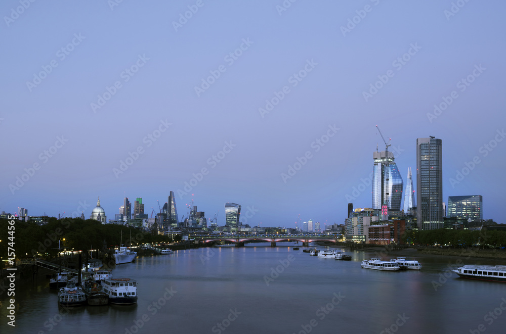 skyscrapers in london city with st paul's cathedral at night seen over thames river