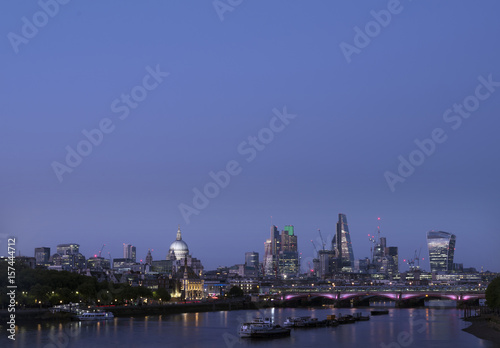 skyscrapers in london city with st paul s cathedral at night seen over thames river