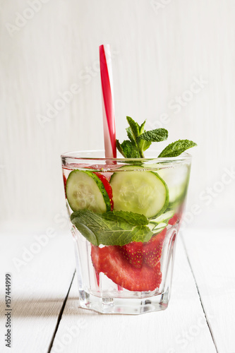 A glass of detox water with strawberries, ice and fresh cucumber. Healthy lifestyle. photo