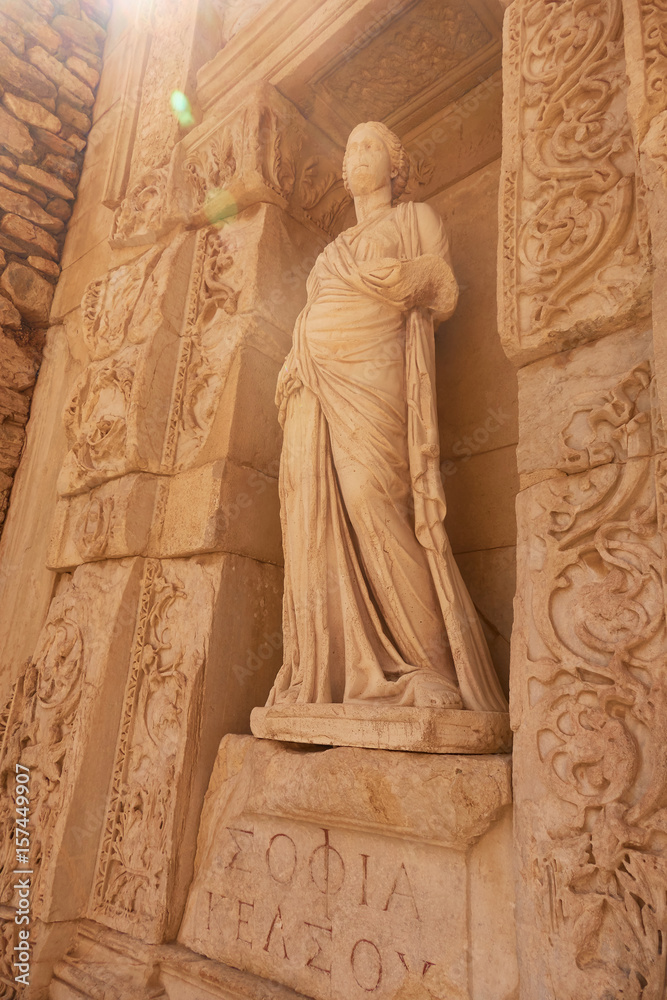 Ancient sculpture in ruins of ephesus in turkey. A ray of light falls on the sculpture of a woman