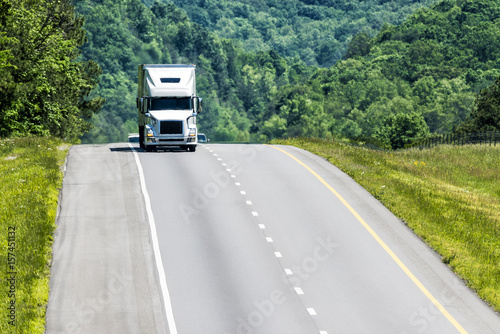 A white eighteen-wheeler coming towards the camera.  Heat waves from the highway create a nice shimmering effect on the truck and background..