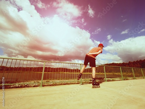 Vintage tone filter effect color style. Sportsman  with inline skates ride in summer park photo