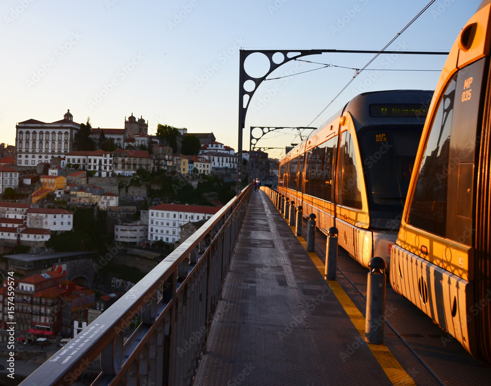 Ponte Dom Luís I during sunset with yellow metro trams - Porto, Portugal