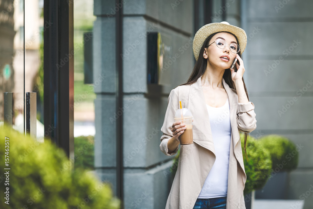 Beautiful young Business Woman using phone. Slow Motion. Beautiful woman in jeans enjoying sunny morning in the city and drinking coffee. Lens Flare. Beautiful young Business Woman using phone. Slow Motion. Beautiful woman in jeans enjoying sunny morning in the city and drinking coffee. Lens Flare.