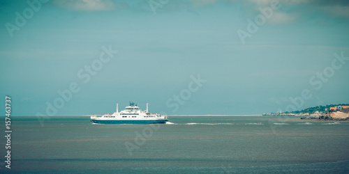 Tableau sur toile a ferry boat is leaving a city to cross the river