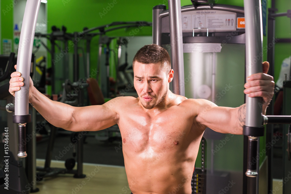 Strong muscular handsome man exercising at the gym Strong muscular handsome man exercising at the gym
