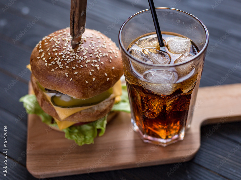 Delicious double burger with cola on a beautiful background Delicious double burger with cola on a beautiful background
