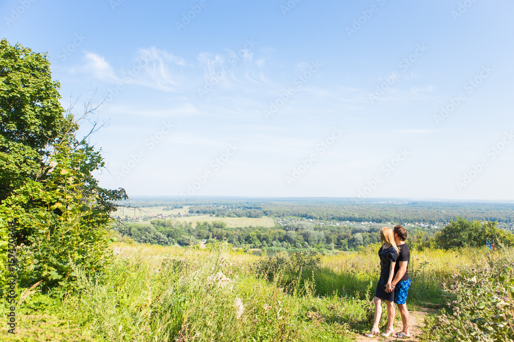 Couple enjoying a walk through grass land and looking far away