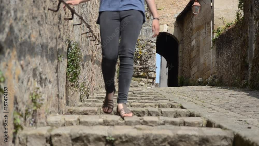 Jeune fille descendant une rue Médiévale en escalier à Autun en Bourgogne
