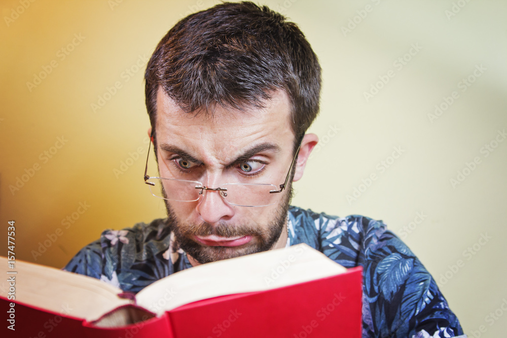 Young man with glasses having troubles reading close and small letters Young man with glasses having troubles reading close and small letters