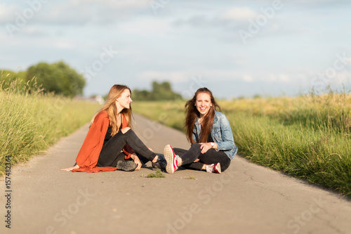 Freundinnen sitzen auf Straße