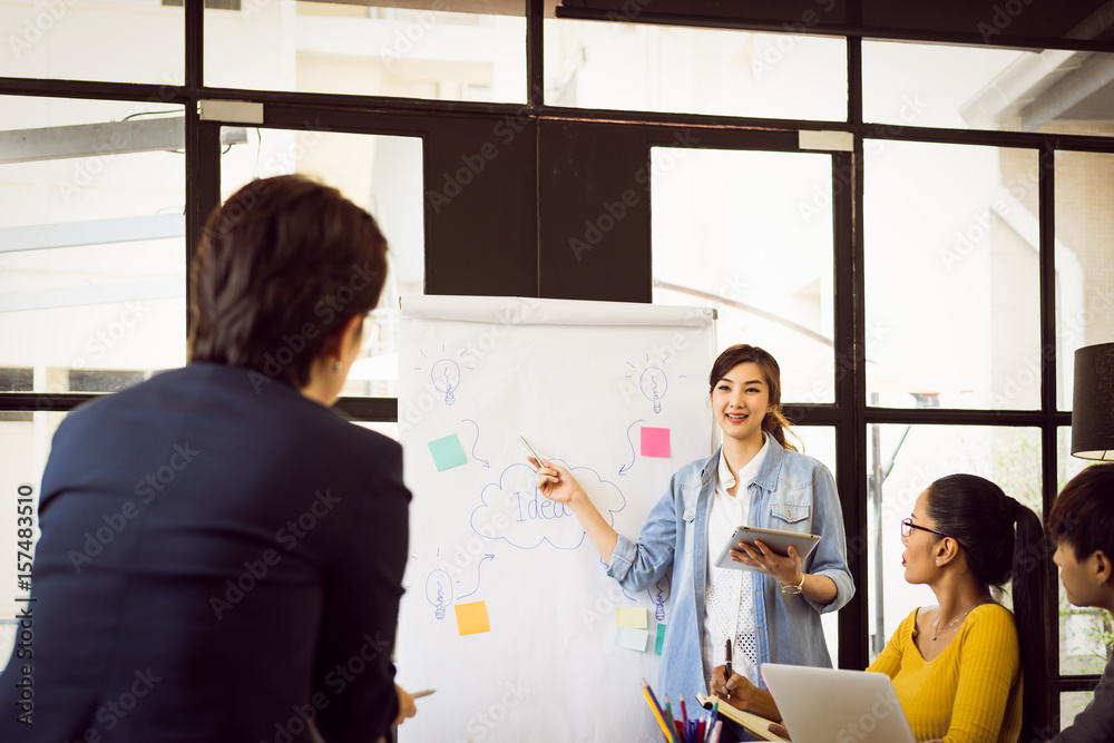 Young charming woman making presentation about new idea by brainstorming meeting in modern office. Young charming woman making presentation about new idea by brainstorming meeting in modern office.