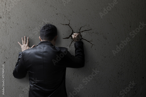 Sad buisness man feeling bad, hopeless, depressed, frustrated and repressed, Man hit the wall. Wall crack.