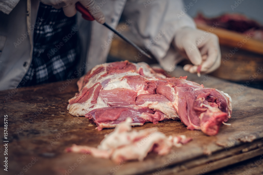Close up image of a man cut fresh pork meat.