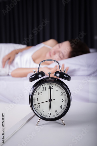 clock show 6 O'clock and woman sleeping on bed