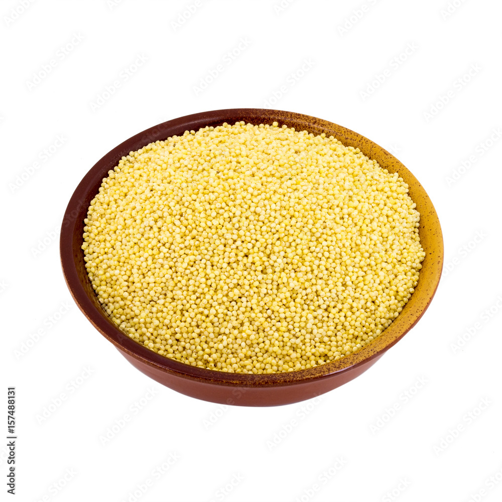 Dry millet in a bowl isolated on white. Spilled millet. Dry millet in a bowl isolated on white. Spilled millet.