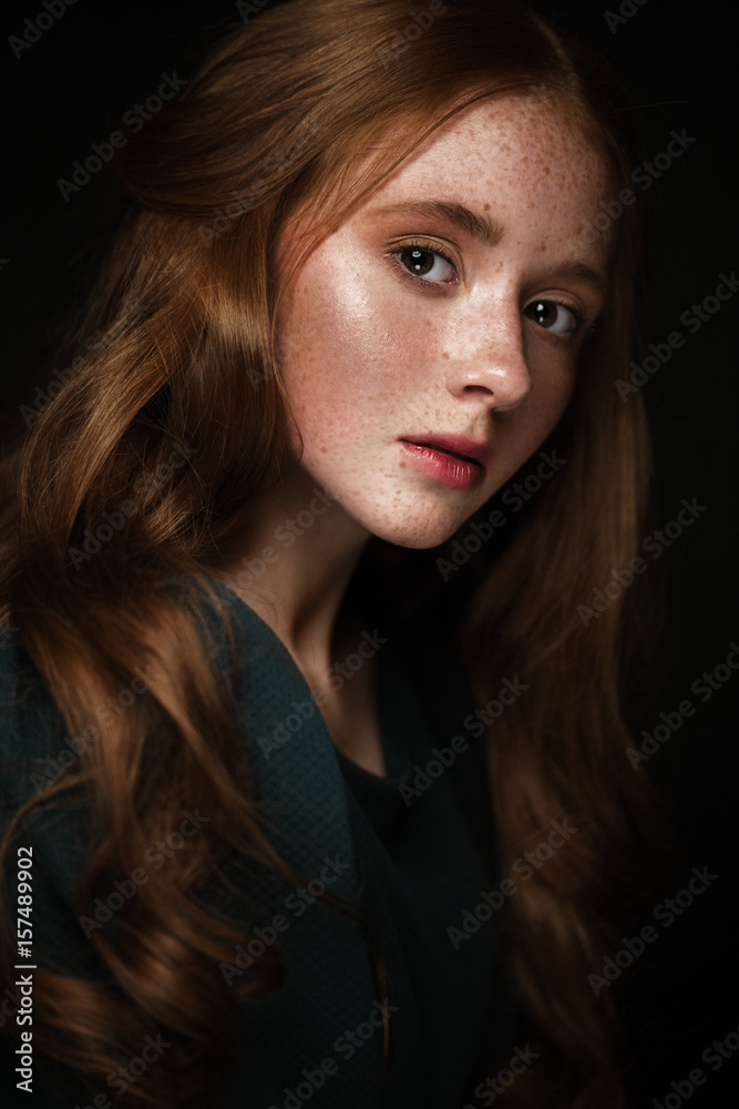 Beautiful Redhead girl with a perfectly curls hair and classic make-up. Beauty face. Picture taken in the studio. Beautiful Redhead girl with a perfectly curls hair and classic make-up. Beauty face. Picture taken in the studio.