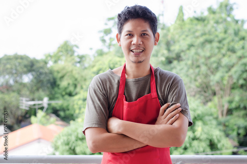 Portrait of Asian man wear red apron ready to working