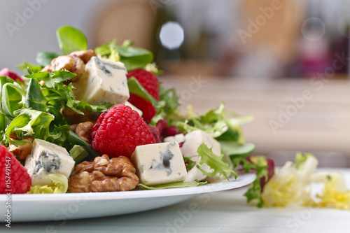 Green salad with blue cheese , raspberry and nuts