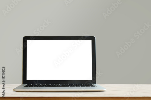 Mock up Blank screen laptop on wooden table with green pastel wall. For product and graphic display montage.