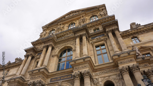 Photo of iconic Louvre Palace on a cloudy spring morning, Paris, France