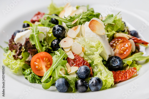 Vegetarian spring salad with greens, nuts and blueberries