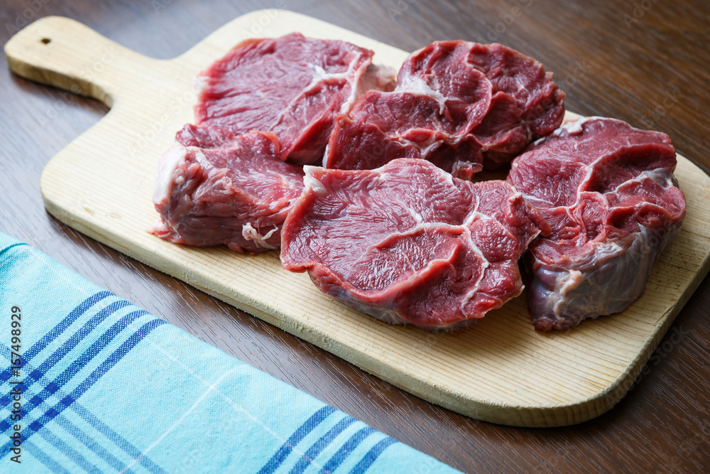 Fresh raw beef on wooden cutting plate