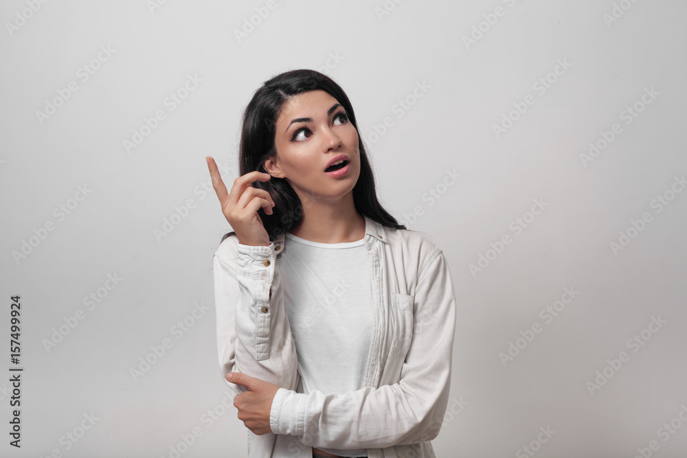 Eureka! Portrait of charming young brunette lady looking away, lifting her finger up, she came up with a brilliant idea Eureka! Portrait of charming young brunette lady looking away, lifting her finger up, she came up with a brilliant idea