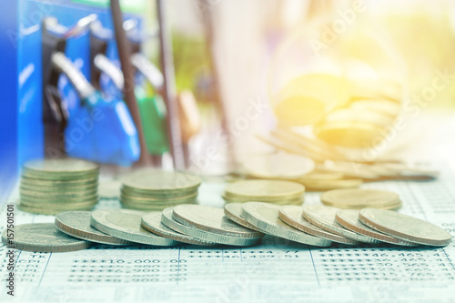 Double exposure of coins and fuel pump background photo