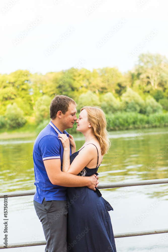 summer holidays, love, romance and people concept - happy smiling young couple hugging outdoors summer holidays, love, romance and people concept - happy smiling young couple hugging outdoors