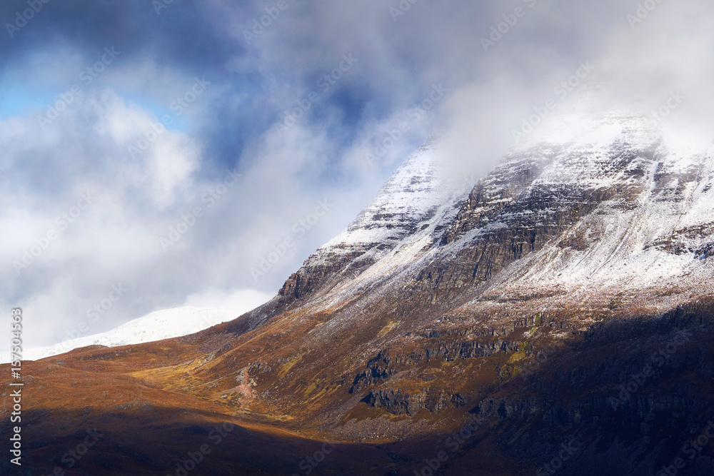 A snow and cloud covered summit of Slioch above Loch Maree in the Scottish Highlands, Scotland, UK.