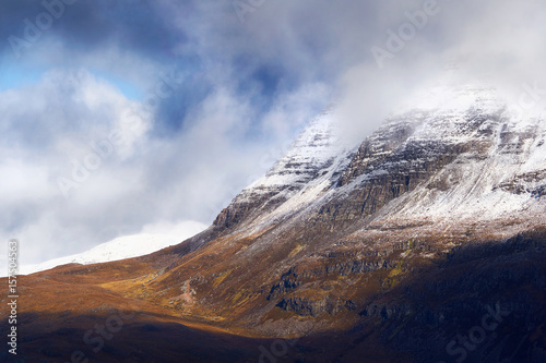 A snow and cloud covered summit of Slioch above Loch Maree in the Scottish Highlands, Scotland, UK.