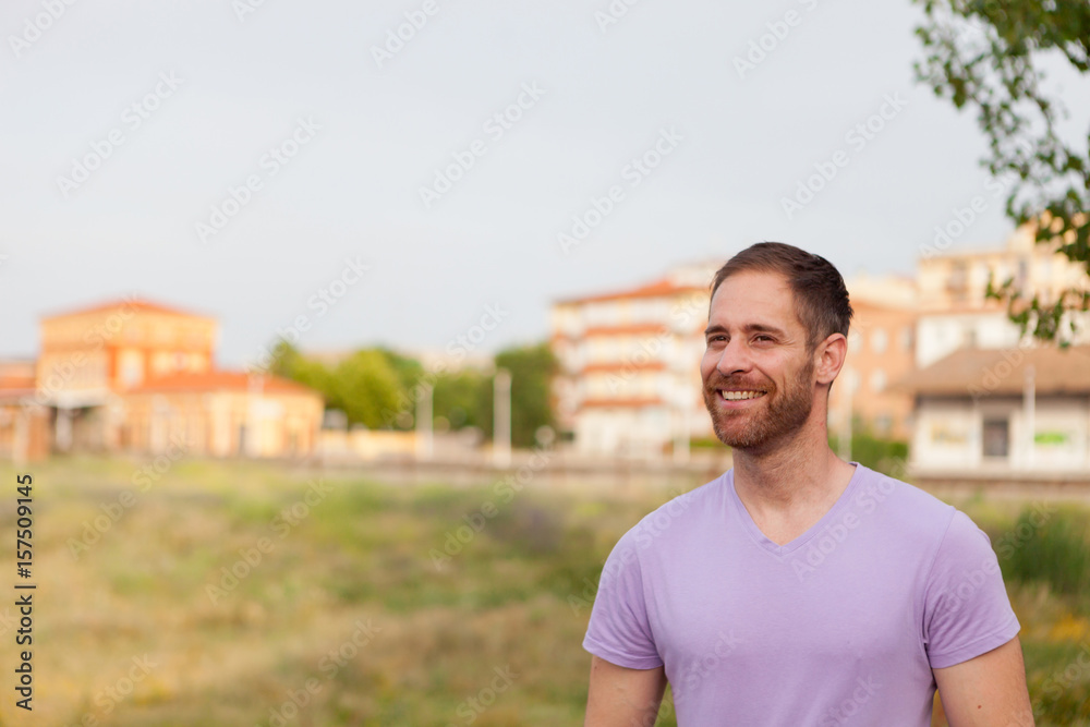 Attractive happy guy with beard and purple tshirt Attractive happy guy with beard and purple tshirt