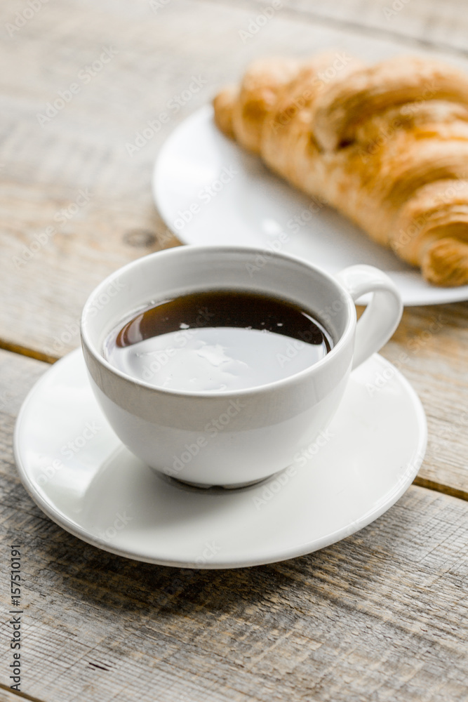 Office lunch with coffee and croissant on wooden table background Office lunch with coffee and croissant on wooden table background
