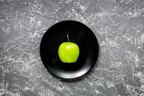 green fresh vegetables, fruits and apple on plate for healthy salad dark background top view photo