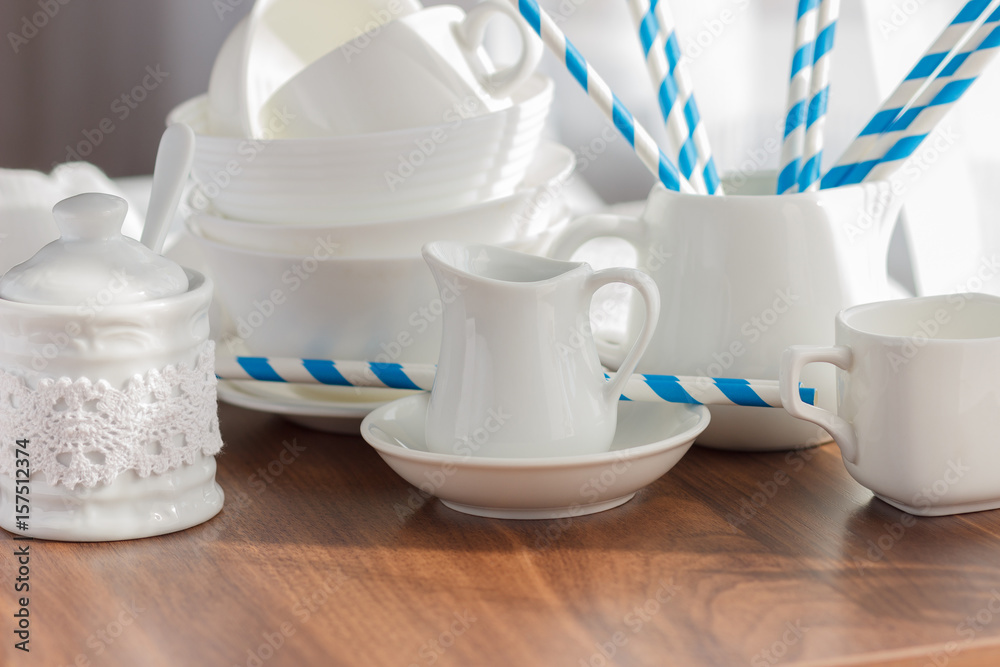 Set of white empty tableware with striped tubules Set of white empty tableware with striped tubules