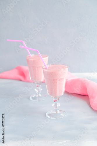 Fresh and Cold Strawberry Smoothie in Tall Glasses on Grey Background  photo