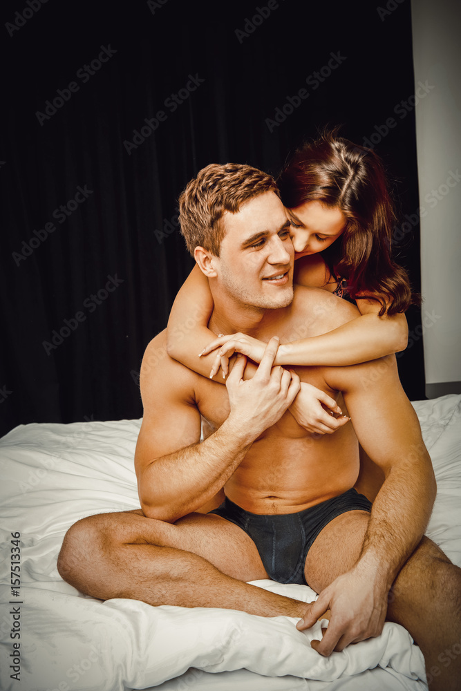 Naklejka premium Young couple sitting on bed