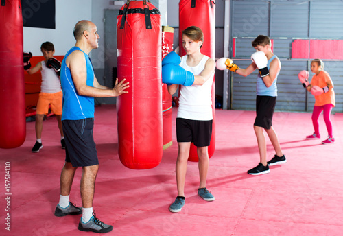 Boxing instructor and young children practicing blows