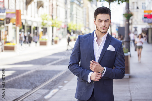 Young handsome businessman dressed smartly, walking through the city