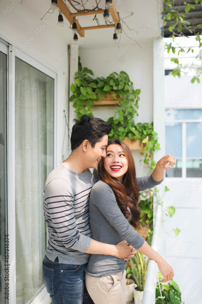 Couple in love sharing genuine emotions and happiness, hugging on the balcony Couple in love sharing genuine emotions and happiness, hugging on the balcony
