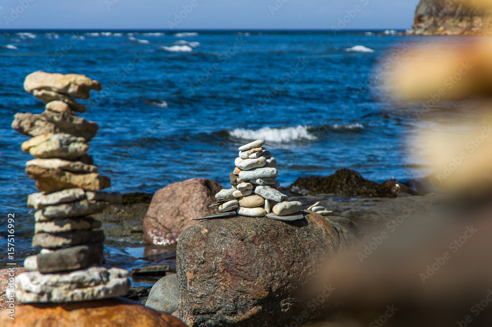 Fototapeta premium Pyramid of stones on the beach in sunny day
