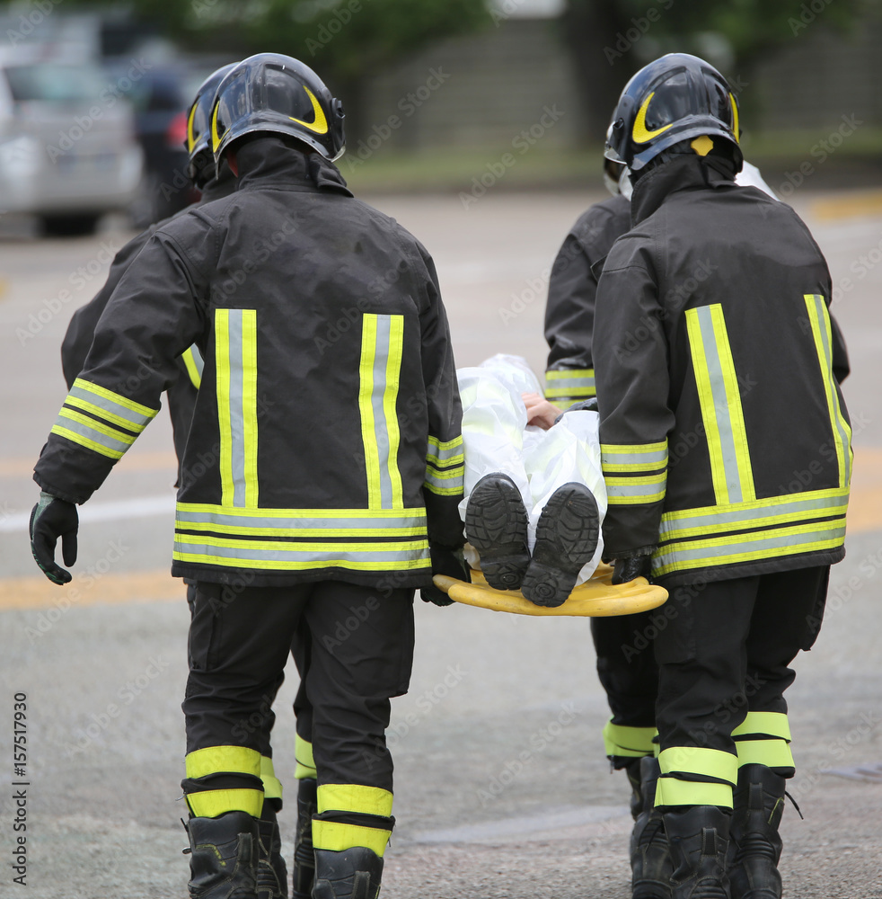 Four brave firemen transport the injured with a stretcher Four brave firemen transport the injured with a stretcher