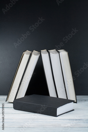 Open books on wooden table, black board background. Back to school. Education business concept.