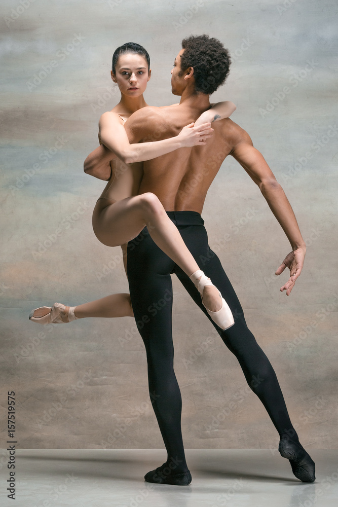 Couple of ballet dancers posing over gray background Couple of ballet dancers posing over gray background