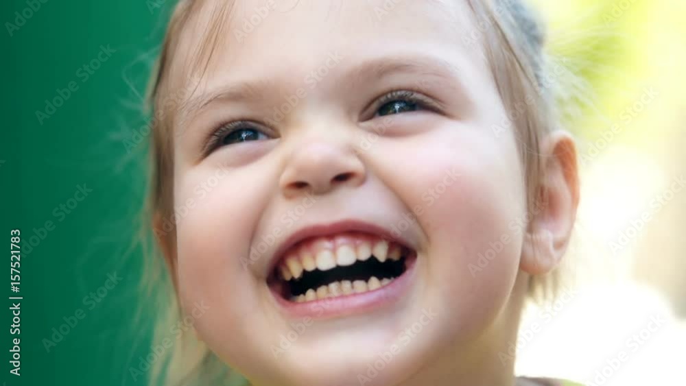 Little beautiful girl laughing and looks at the camera. Real emotions. Closeup video. Slow motion. Little beautiful girl laughing and looks at the camera. Real emotions. Closeup video. Slow motion.