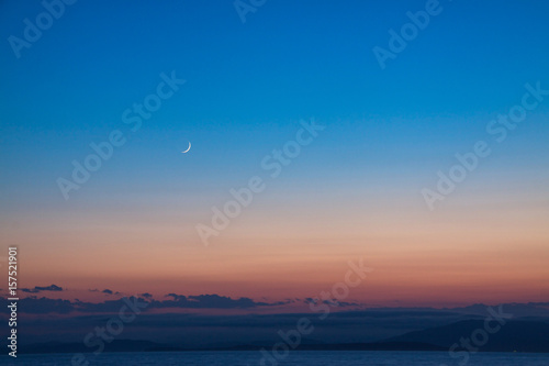 New moon in the sky over the Japanese sea.